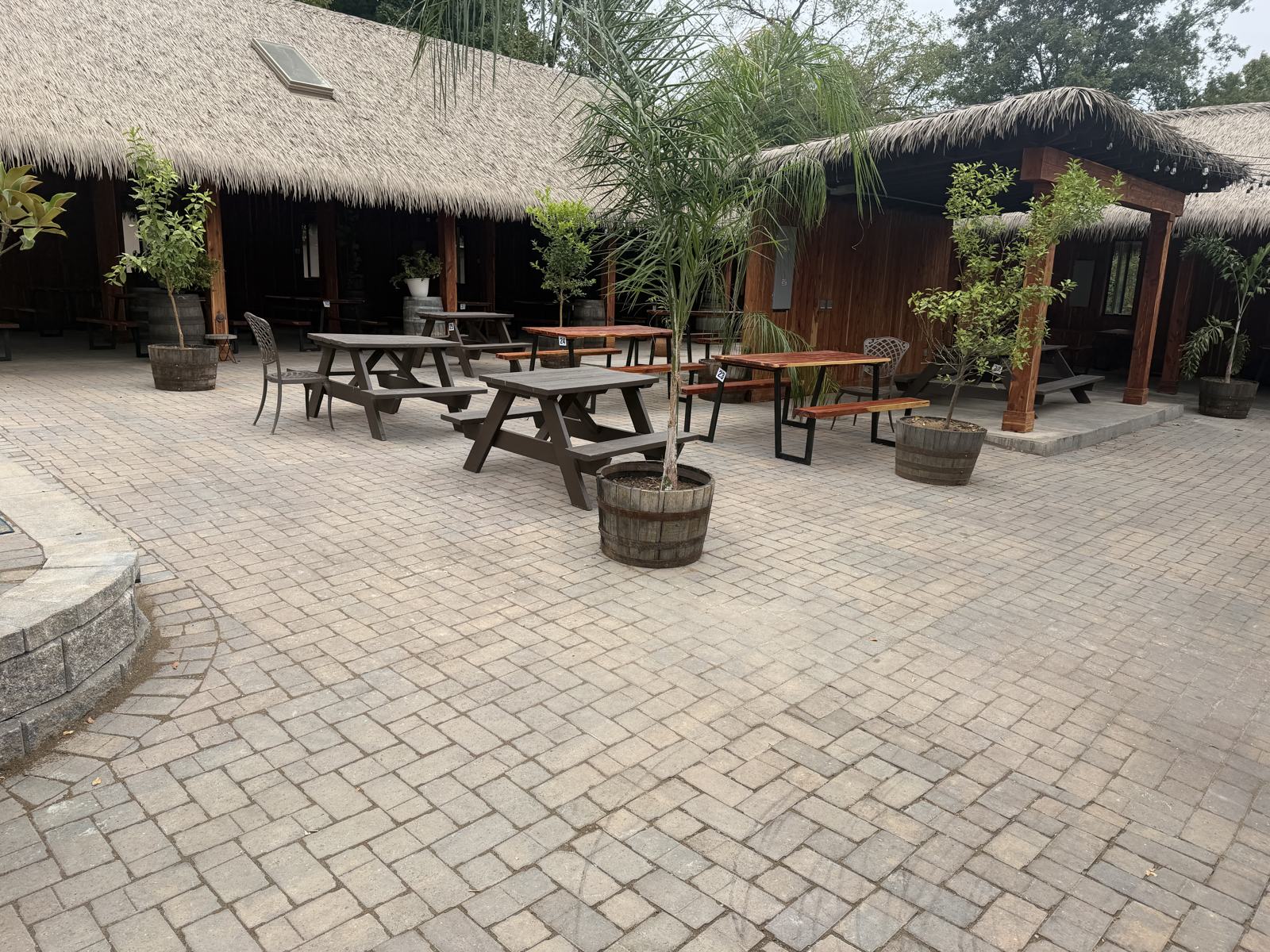Belgard Aqua-Bric herringbone permeable paver field with picnic tables and barrel planters at El Fuego