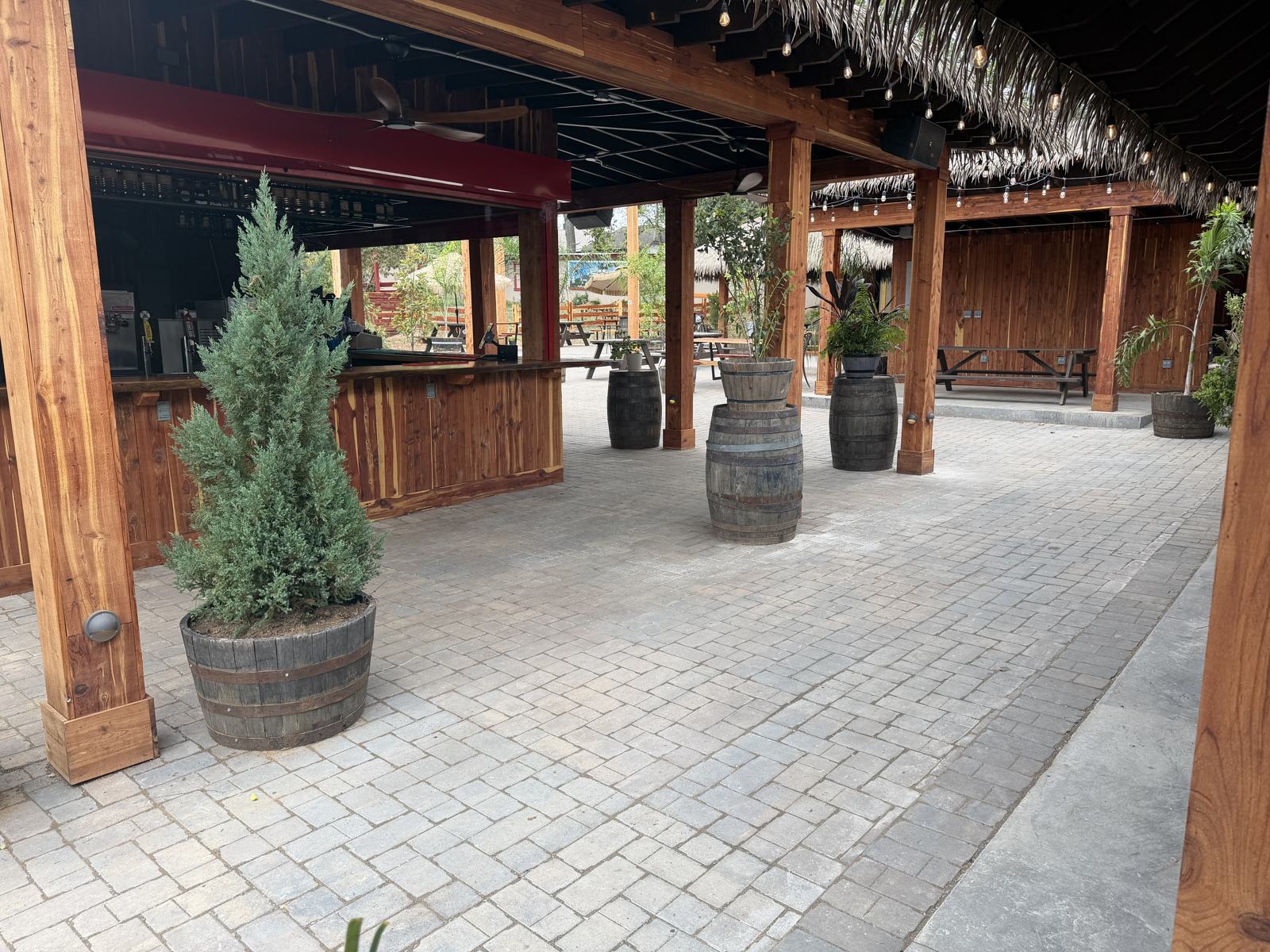Outdoor cedar bar with barrel high-tops on Belgard Aqua-Bric permeable pavers