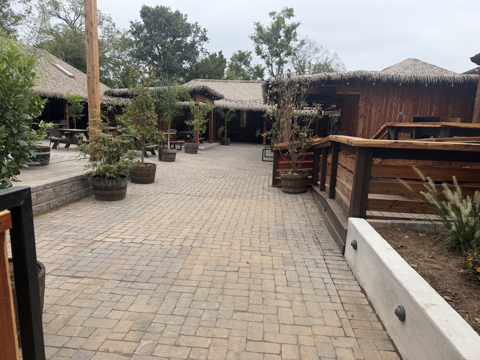 Paver walkway leading from the entrance toward the thatched bar buildings