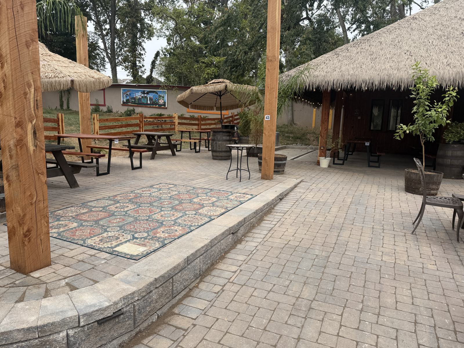 Raised terrace with outdoor rug beside the El Fuego mural wall