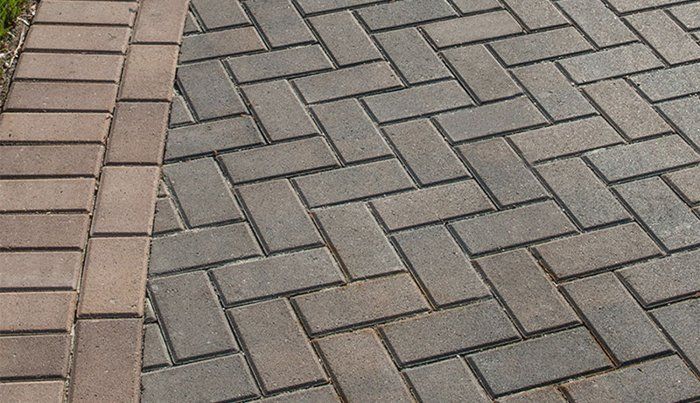 Holland Stone Graphite pavers in herringbone with a red brick soldier-course border