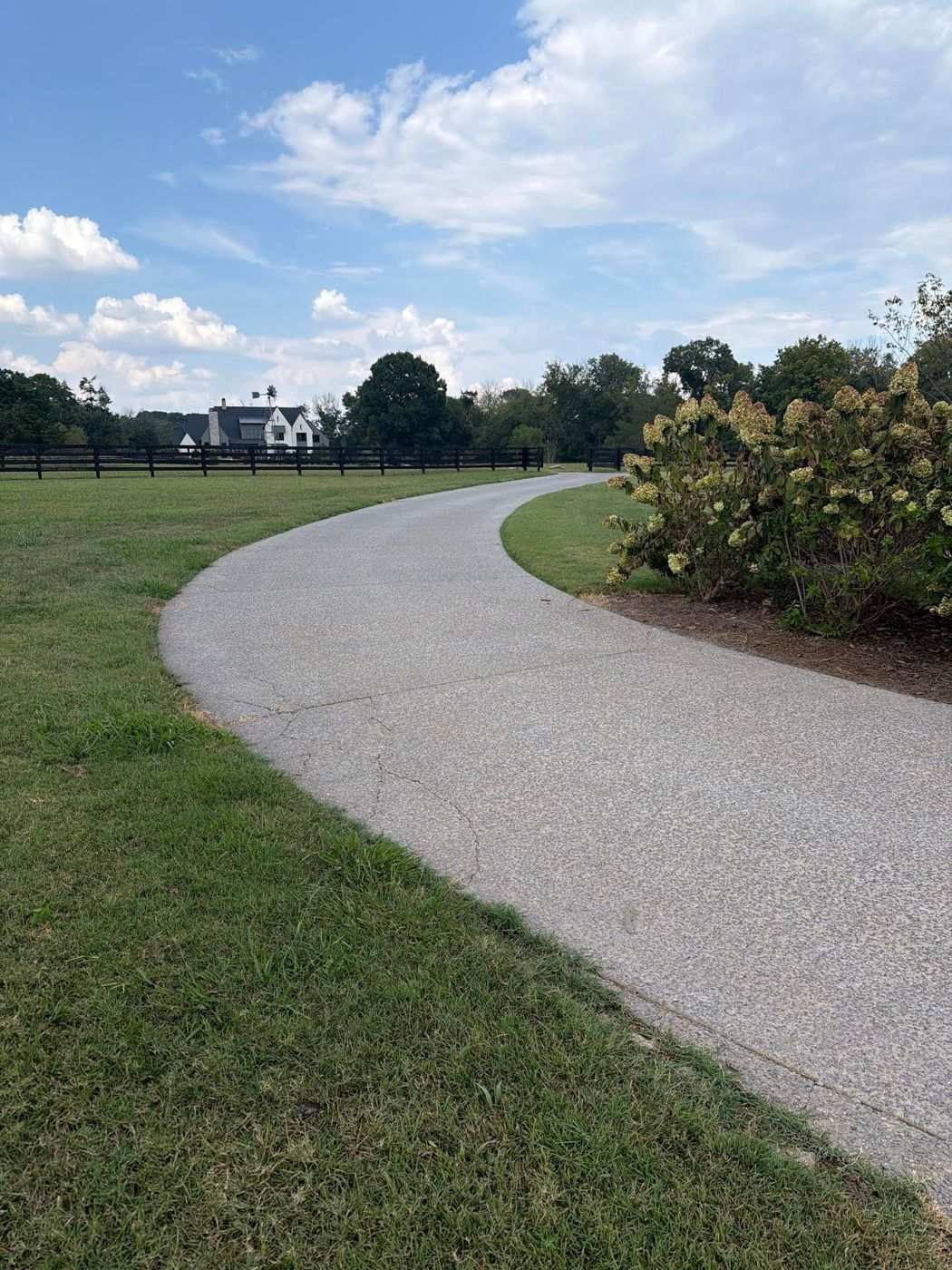 Cracked exposed-aggregate concrete driveway in Franklin TN before paver overlay