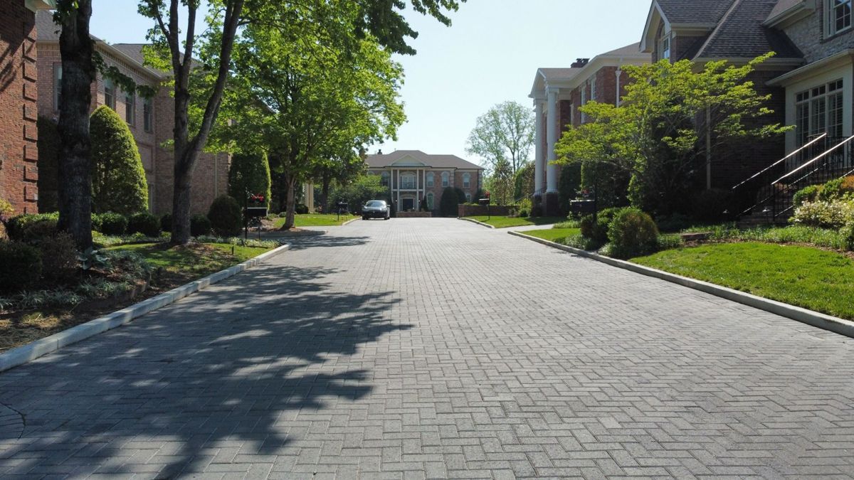 Charcoal herringbone paver overlay on an HOA entrance drive in Nashville