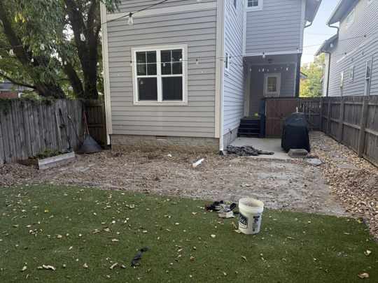Small East Nashville backyard stripped to gravel between synthetic turf and the house, before paver patio