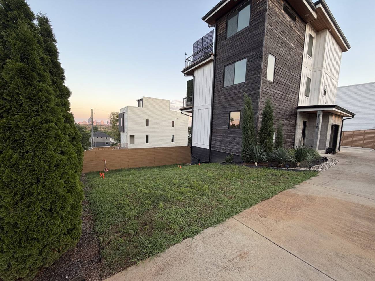 Sloped side yard beside a modern home in Bordeaux Nashville before terracing